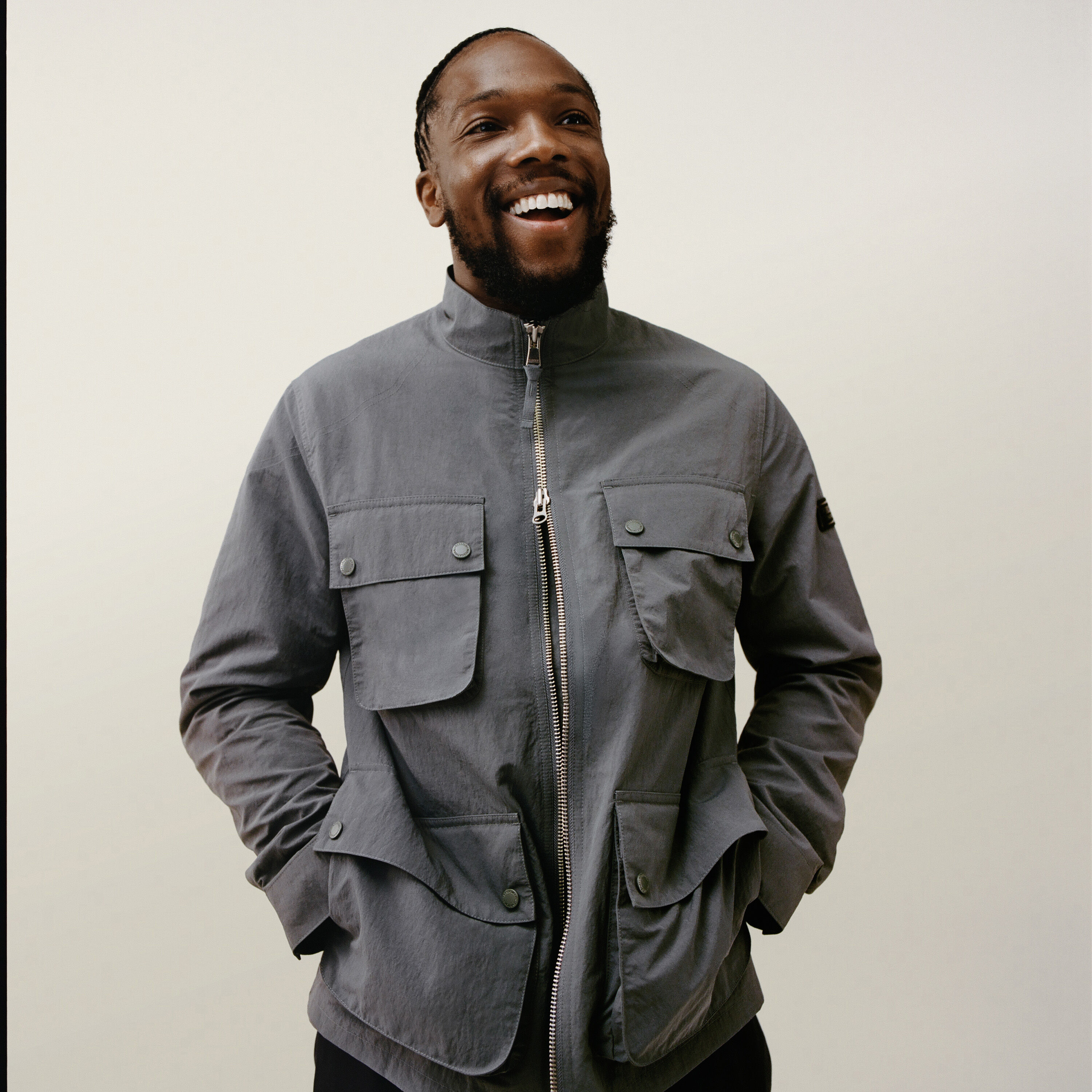Tosin Cole wearing the Course Showerproof Jacket in Washed Charcoal