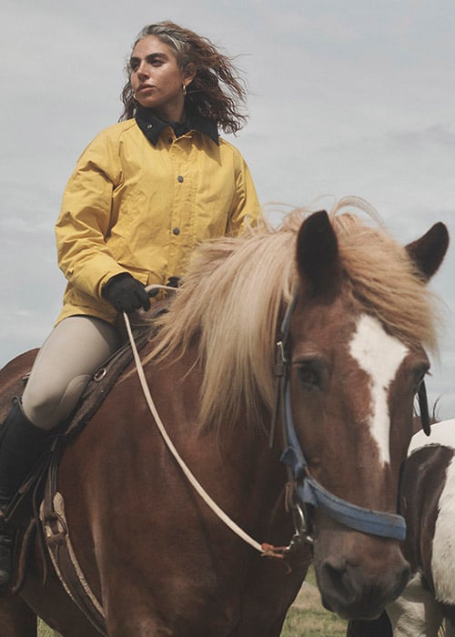woman styling Barbour X Noah collection at stables