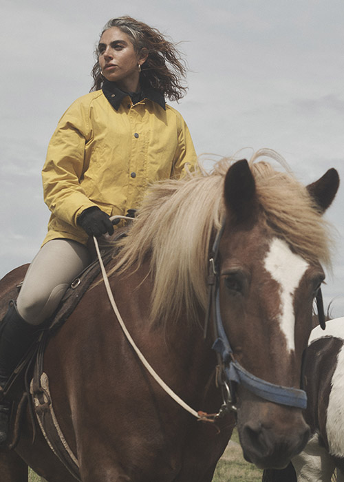 woman styling Barbour X Noah collection at stables