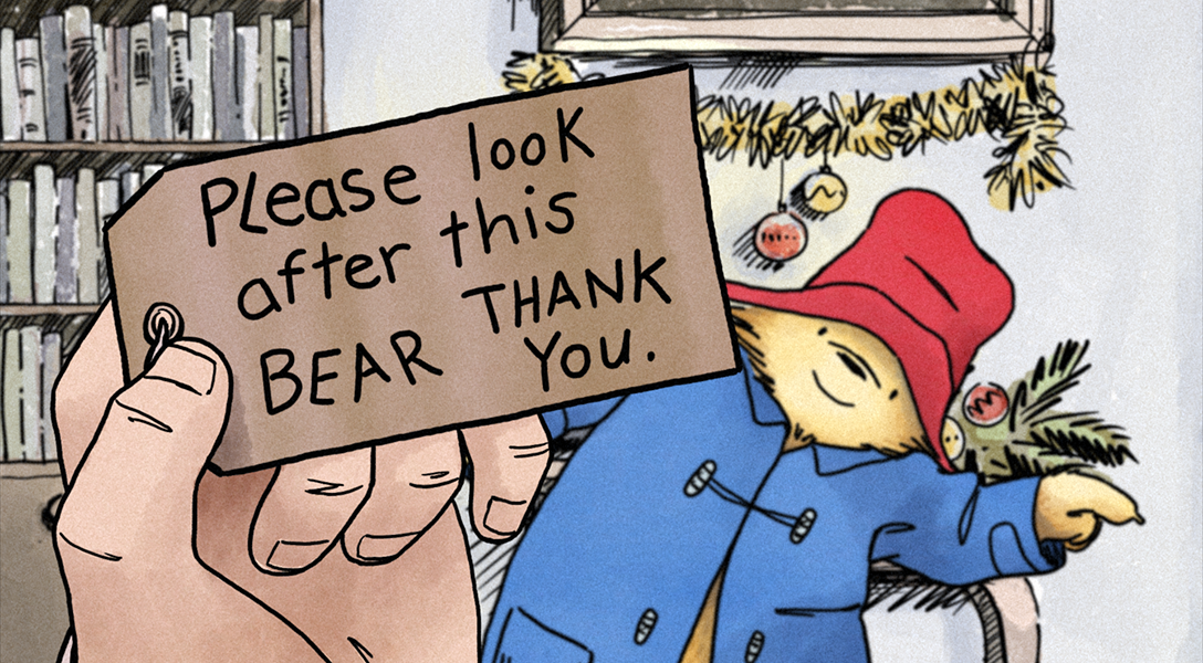 Paddington watches as Mr Brown reads the tag that says Please Look After this Bear